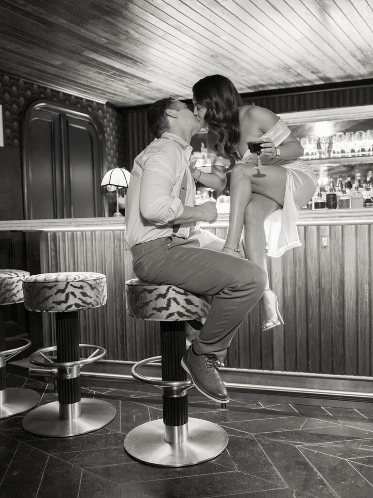 Couple kisses at bar during Boston engagement photos in Beacon Hill at 89 Charles bar