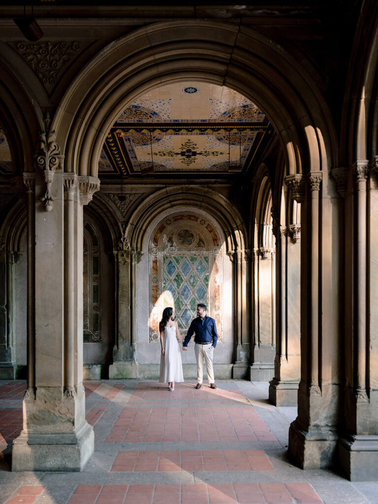 Couple portrait under Bethesda Terrace arcade arches Central Park engagement session