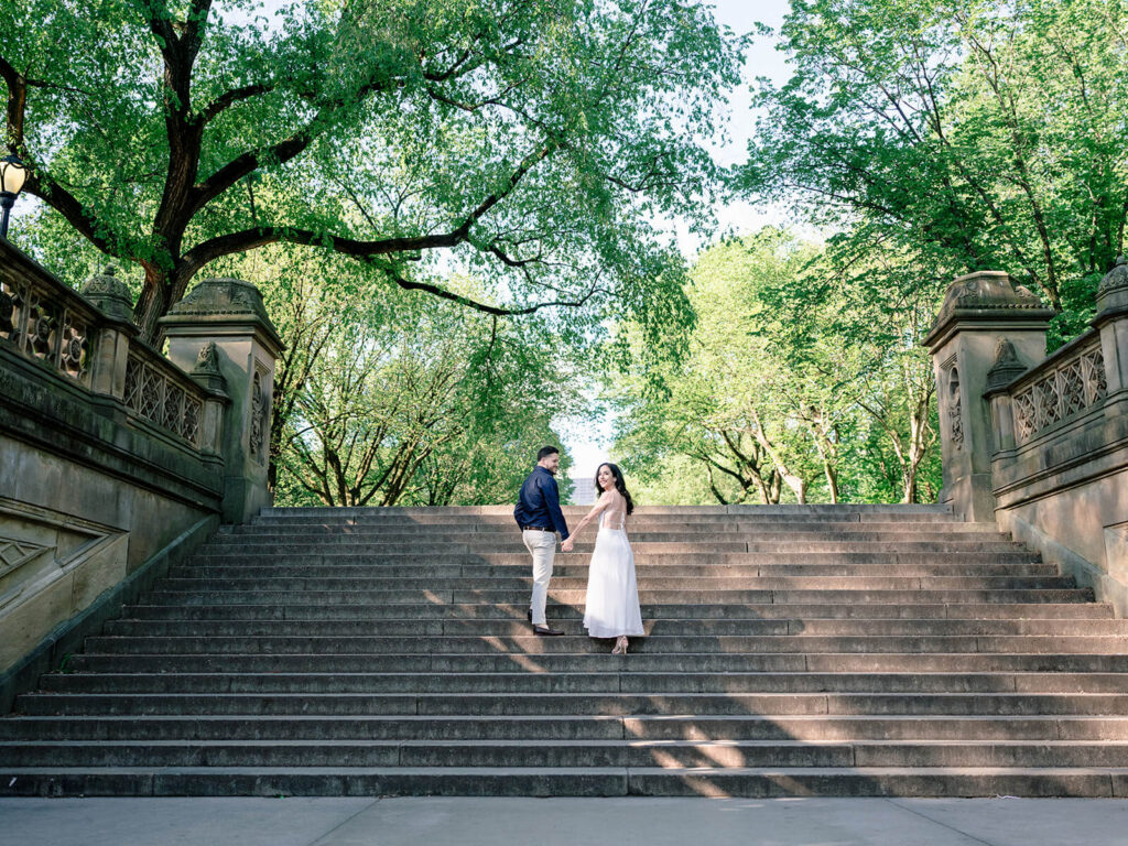 Romantic couple ascending stairs at Bethesda Terrace Central Park NYC engagement photos