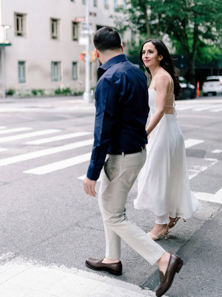 Couple walking hand-in-hand on Bethesda Terrace steps Central Park engagement