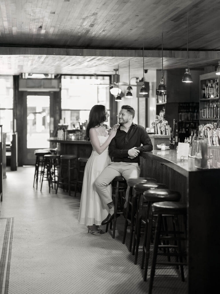 Engaged couple on grand staircase at Bethesda Terrace with lush park greenery