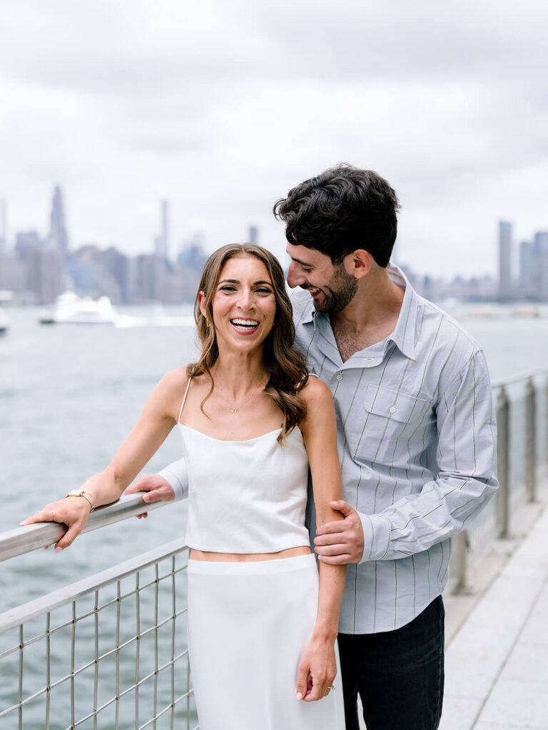 Engaged couple walking hand in hand along Williamsburg Brooklyn waterfront