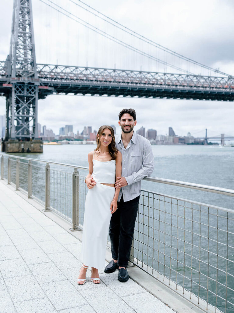 Romantic couple portrait at Domino Park Brooklyn with bridge backdrop engagement photos