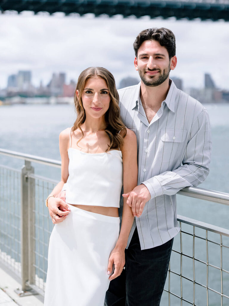 Brooklyn NYC engagement photography at Domino Park waterfront with bridge views