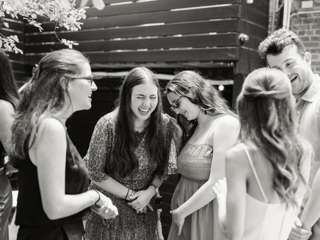 Friends celebrating together at Brooklyn engagement party with genuine laughter
