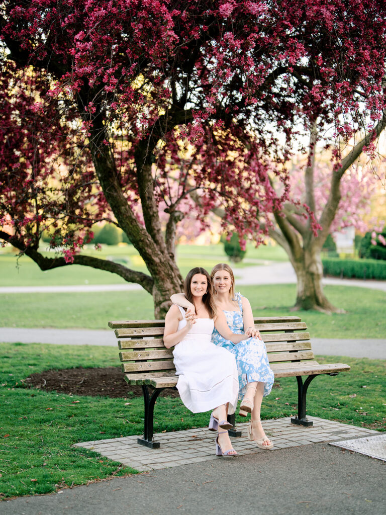 Two brides walking hand-in-hand through Boston Common during golden hour engagement