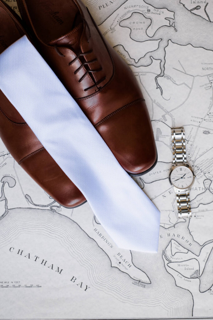 Groom details with brown shoes, tie, watch, and map for a Chatham Bars Inn wedding on Cape Cod