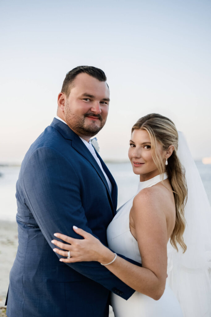 Bride and groom sitting together on the beach at Chatham Bars Inn