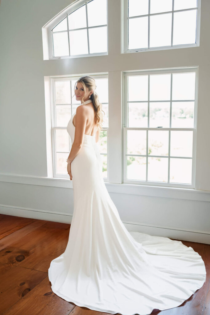 Bride in her wedding dress by the window at Chatham Bars Inn on Cape Cod