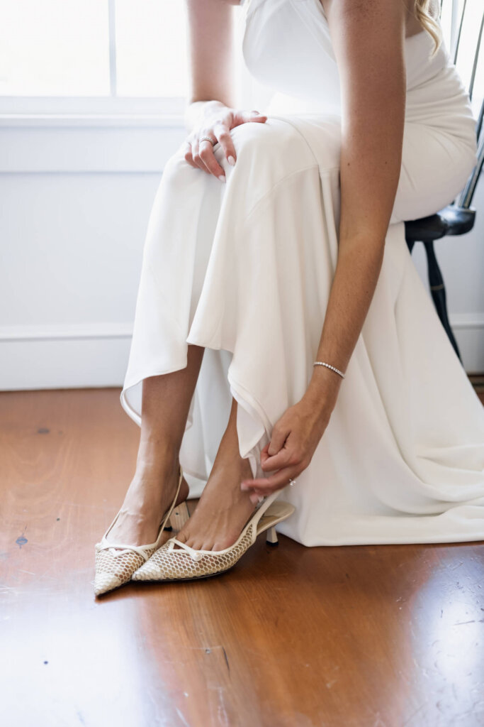 Bride putting on her wedding shoes before the ceremony in Chatham, Massachusetts