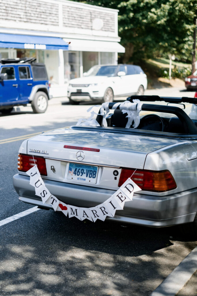Just married getaway car decorated with a banner outside St. Christopher’s Episcopal Church in Chatham