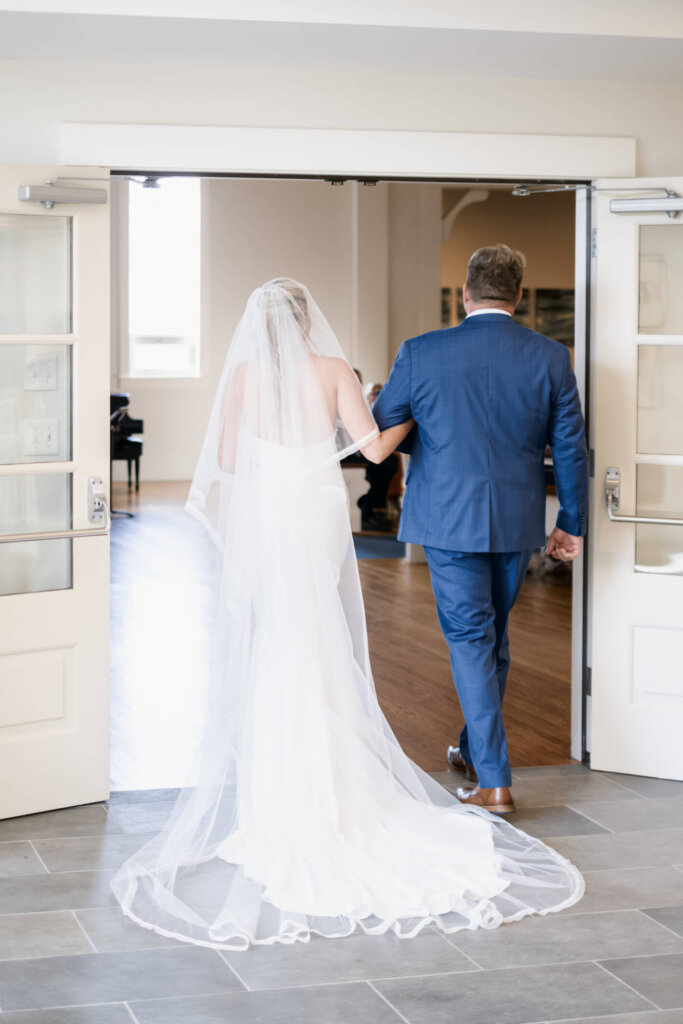 Bride walking with her father into St. Christopher’s Episcopal Church in Chatham