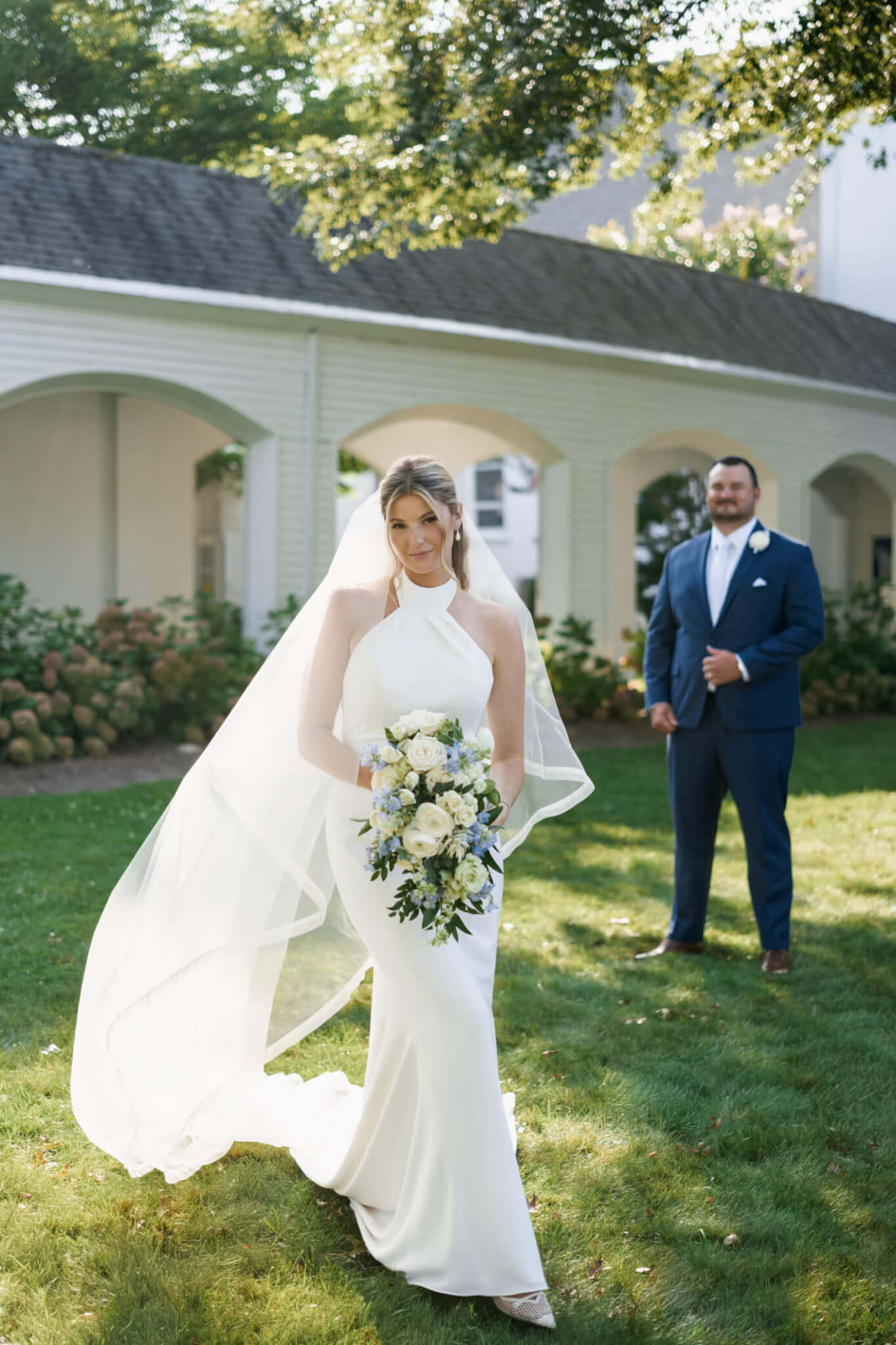 Bride and groom kissing beneath white arches at Chatham Bars Inn