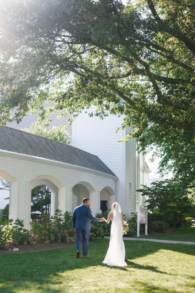 Bride and groom framed by white arches at Chatham Bars Inn on Cape Cod