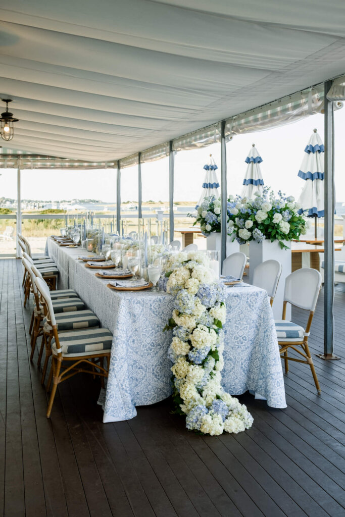Reception table with blue patterned linens and blue and white flowers at Chatham Bars Inn
