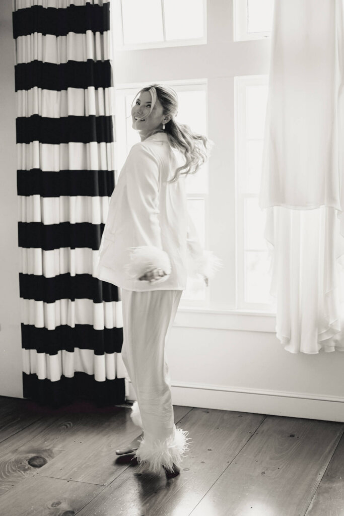 Bride in a white pajama set getting ready at Chatham Bars Inn on Cape Cod
