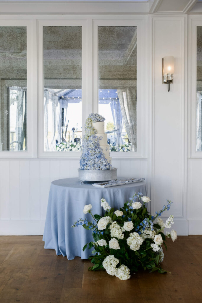 Wedding cake display with blue and white flowers at Chatham Bars Inn