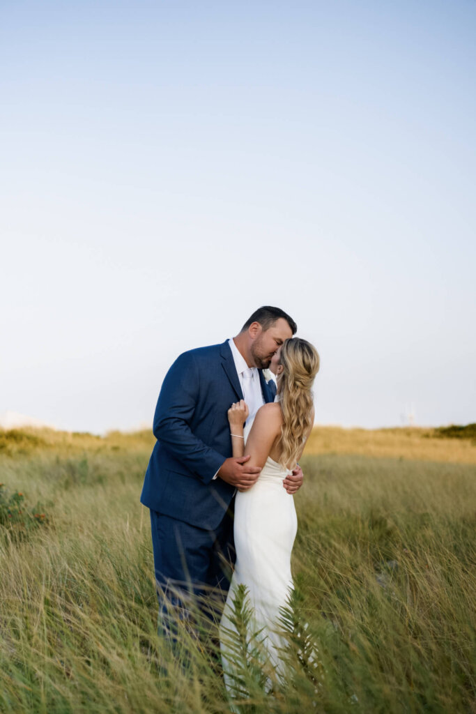 Bride and groom embracing in the dunes at Chatham Bars Inn on Cape Cod