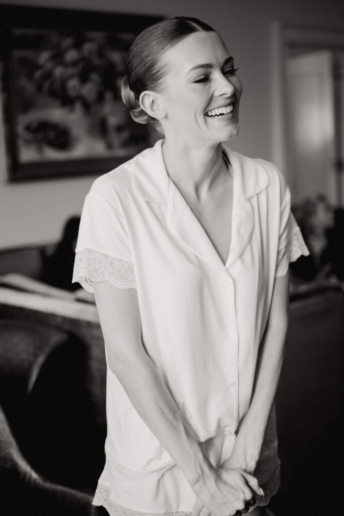 Bride in white pajamas getting ready before her Bedford Golf and Tennis Club wedding outside NYC