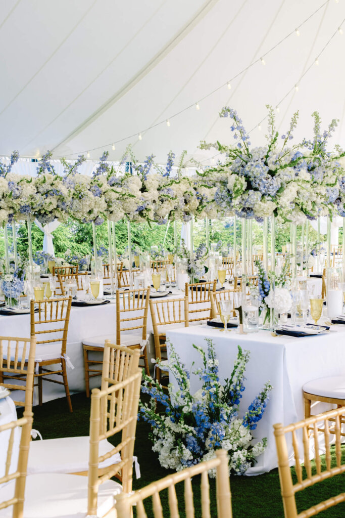 Blue and white floral centerpiece under the reception tent at Bedford Golf and Tennis Club