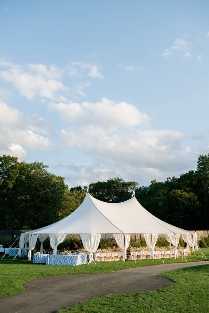 Bride and groom seated inside the reception tent at Bedford Golf and Tennis Club