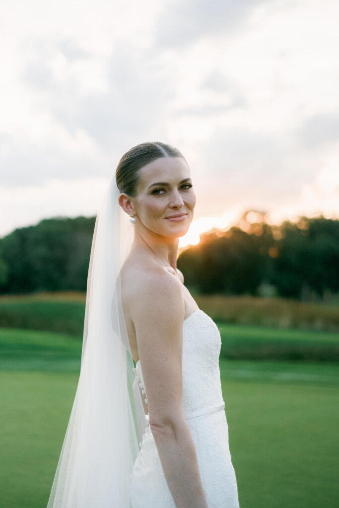 Bride and groom embracing at golden hour outside Bedford Golf and Tennis Club