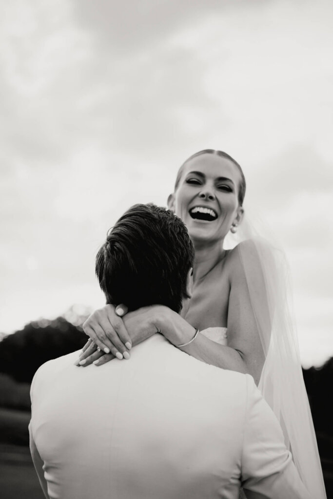 Bride laughing during a reception toast at Bedford Golf and Tennis Club