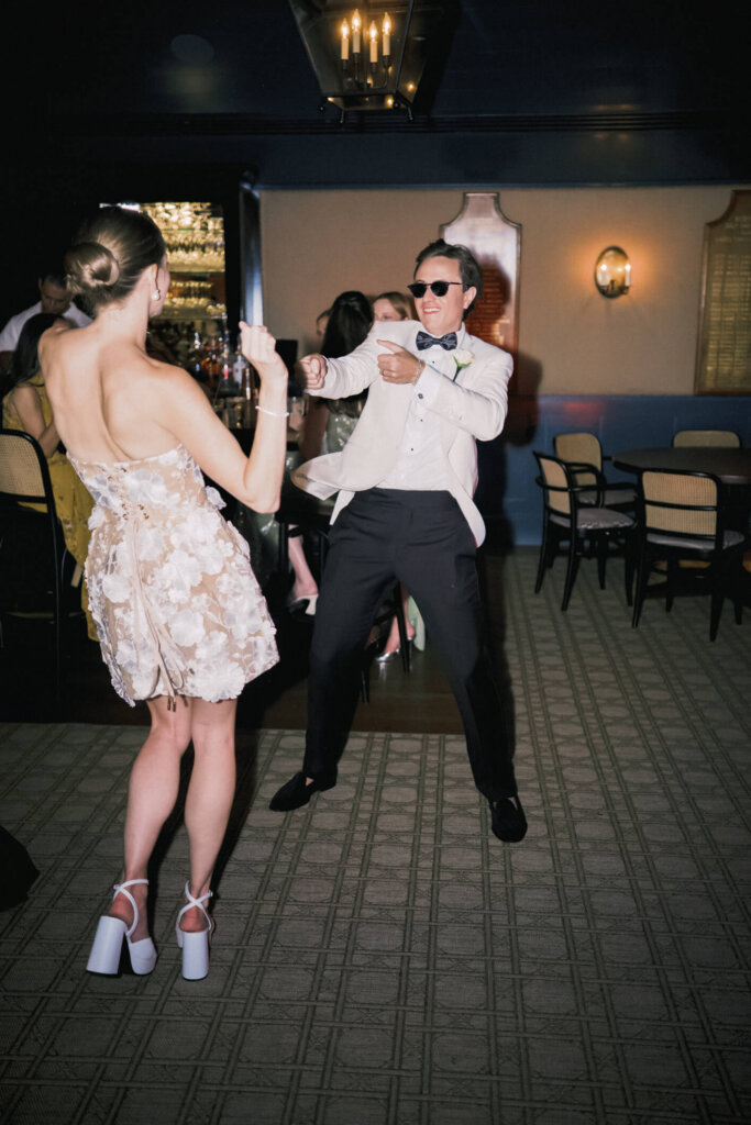 Bride in a short dress dancing under the tent in Bedford, New York