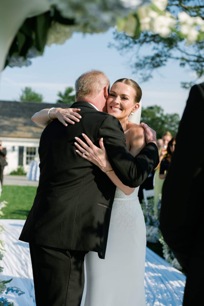Bride hugging a family member during the Bedford Golf and Tennis Club ceremony