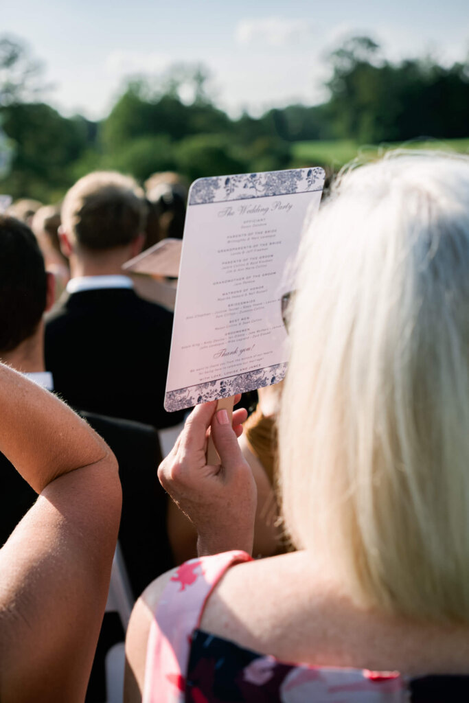Guest holding the ceremony program during a Bedford Golf and Tennis Club wedding