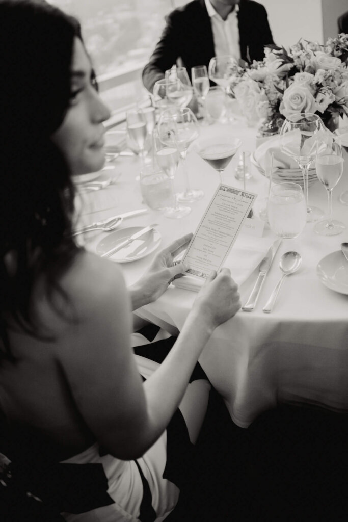 Guest reading the menu at the New York welcome dinner before the Bedford wedding weekend