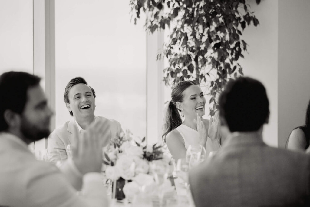 Louise and James laughing during a toast at their New York welcome dinner