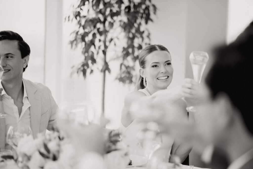 Guest raising a glass during Louise and James’ New York welcome dinner