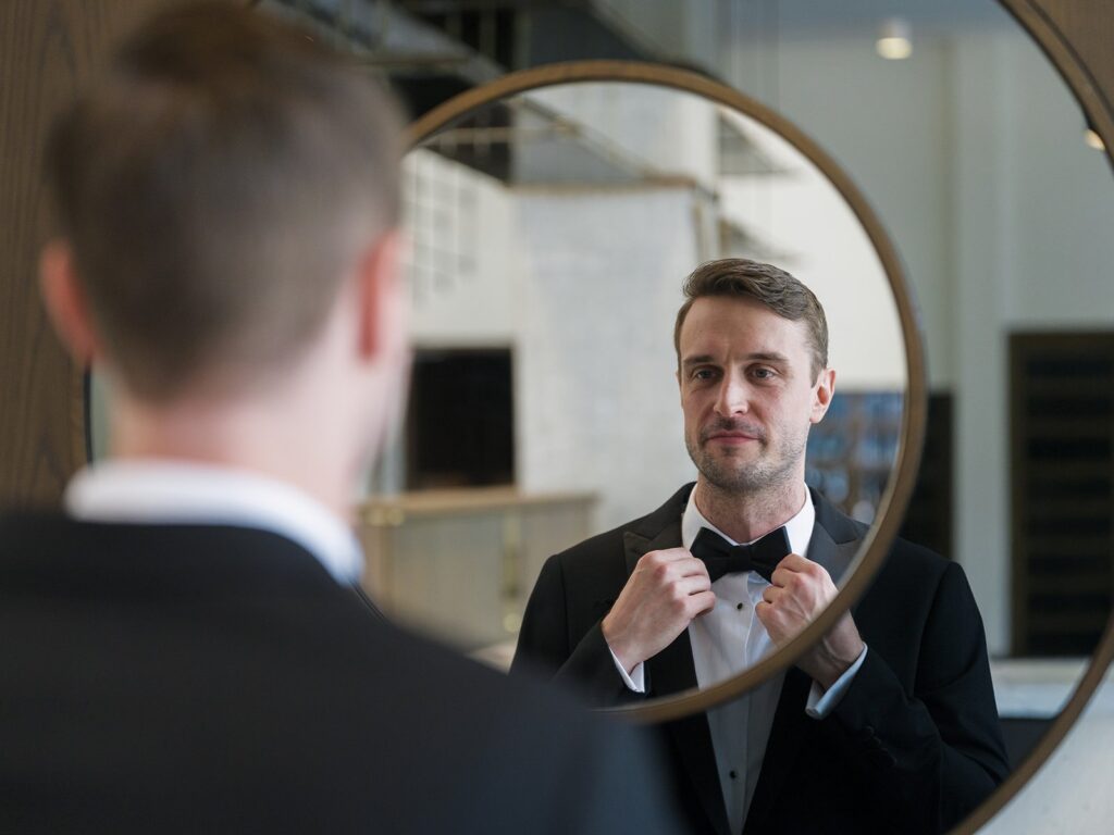 Tim adjusting his bow tie in a hotel mirror