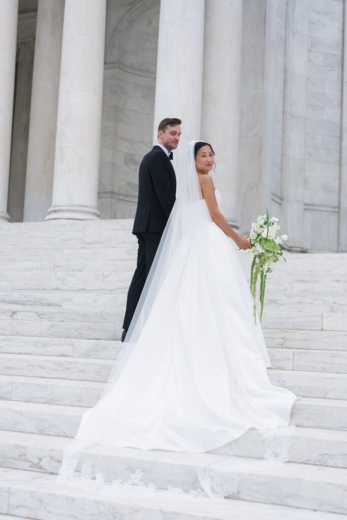 Tiffany and Tim standing beneath the columns of the Jefferson Memorial on their wedding day