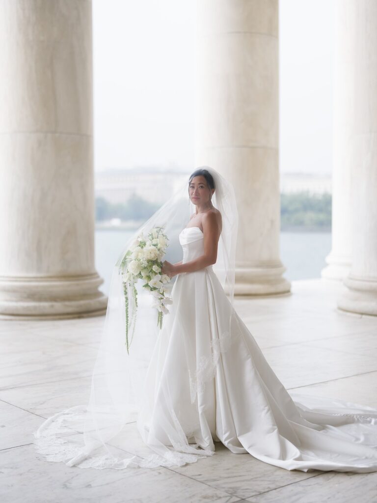 Tiffany holding her bouquet inside the Jefferson Memorial colonnade
