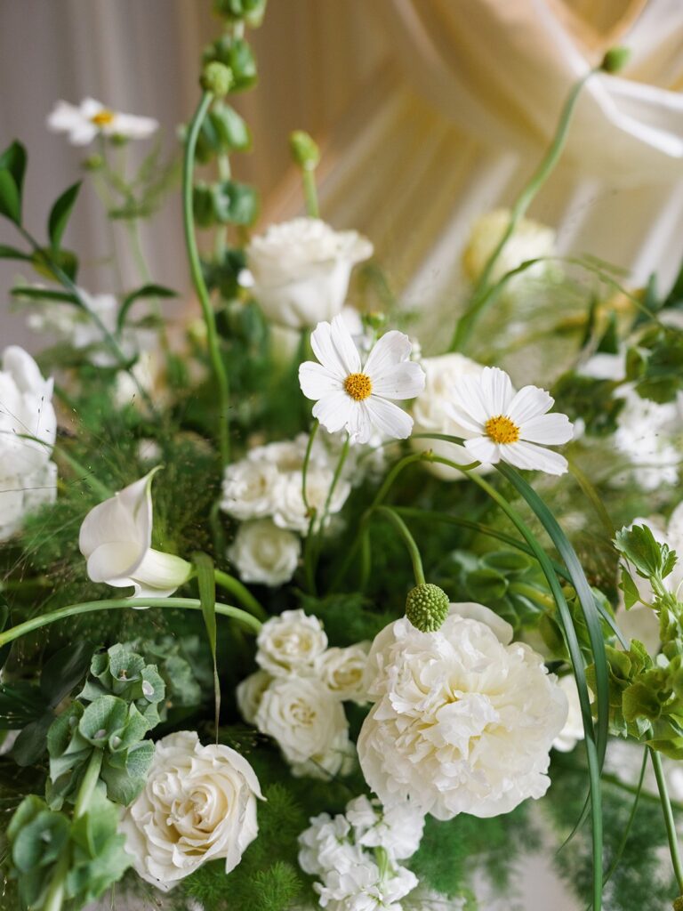 Green-and-white ceremony flowers with white roses and cosmos
