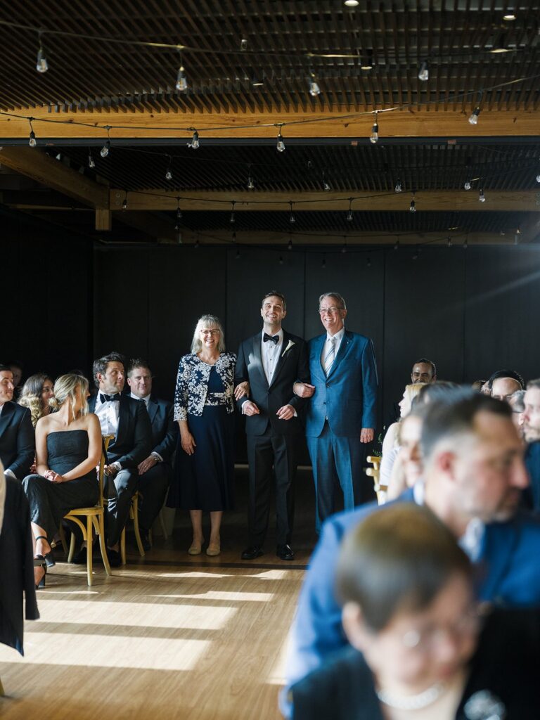 Wedding guests standing as Tiffany enters the District Winery ceremony