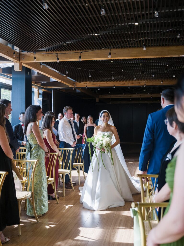 Tiffany walking down the aisle with her mother at District Winery