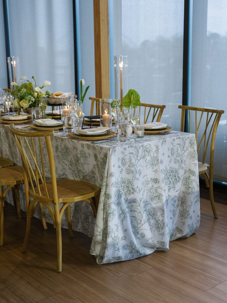 Candlelit District Winery wedding reception with long tables and green-and-white floral arrangements