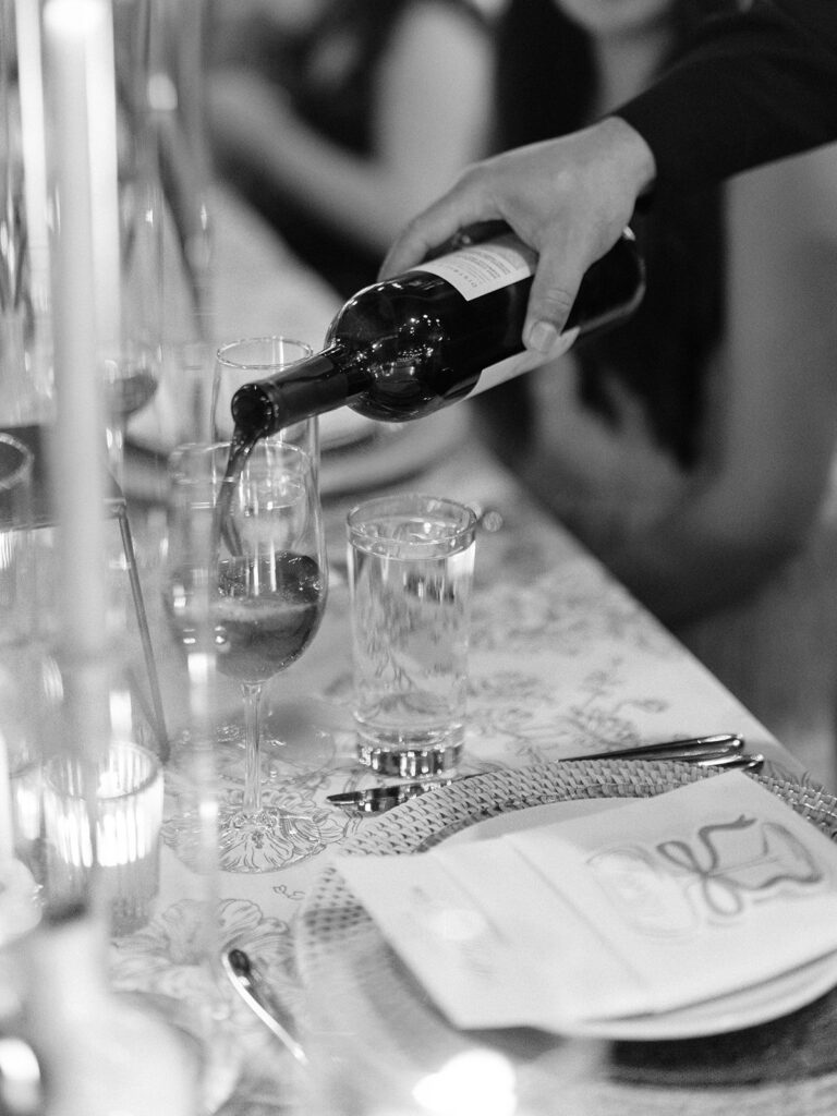Wine being poured at a candlelit District Winery reception table
