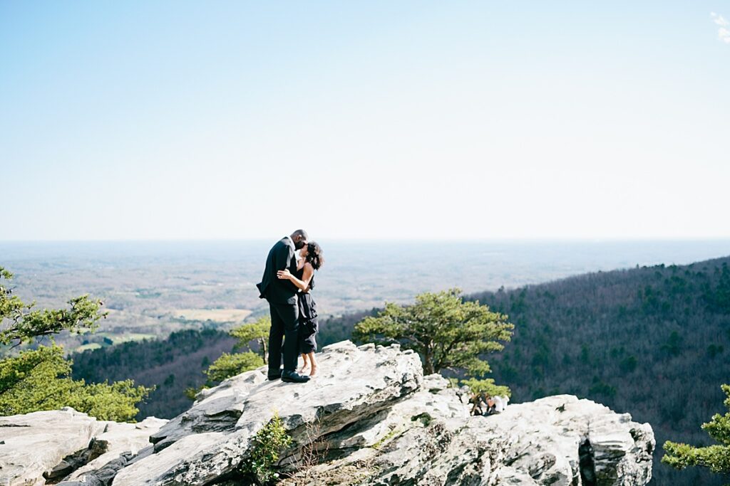 Natural beauty of Hanging Rock: A couple embracing each other on top of Hanging Rock, surrounded by the picturesque natural beauty of the state park.