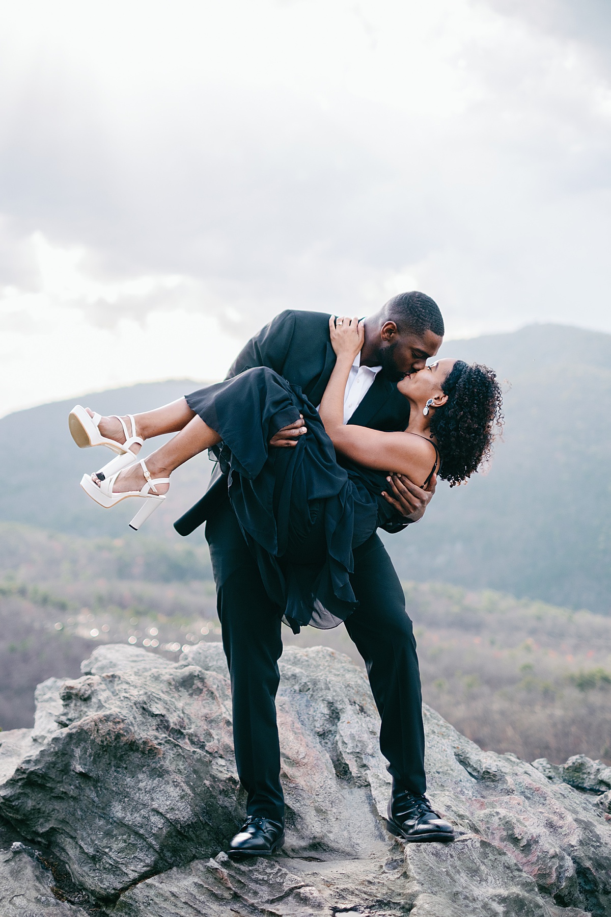 Hanging Rock engagement session: A couple kissing atop Hanging Rock at Hanging Rock State Park.