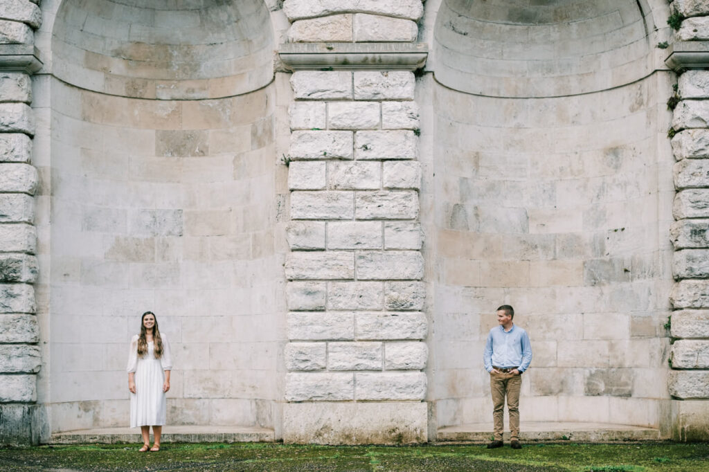 Modern love story in an old-world setting – A wide-angle portrait of the couple standing apart against the grand architecture of Florence, symbolizing connection and distance in an artistic composition.