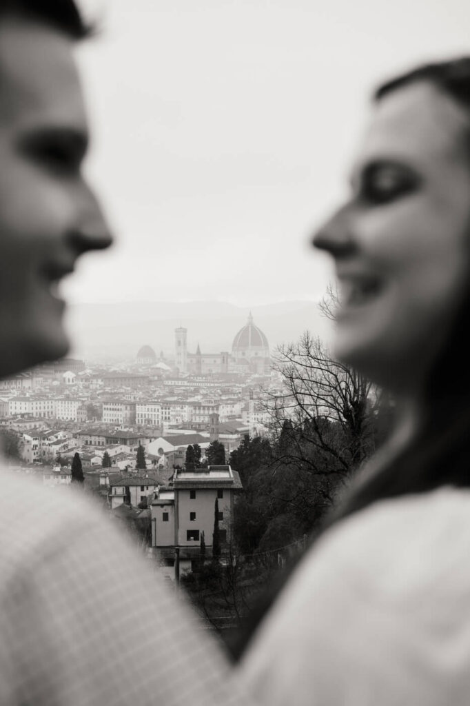 Artistic Florence engagement session with blurred couple – A creative black-and-white photograph captures the Florence skyline framed by the blurred silhouettes of the couple in the foreground.