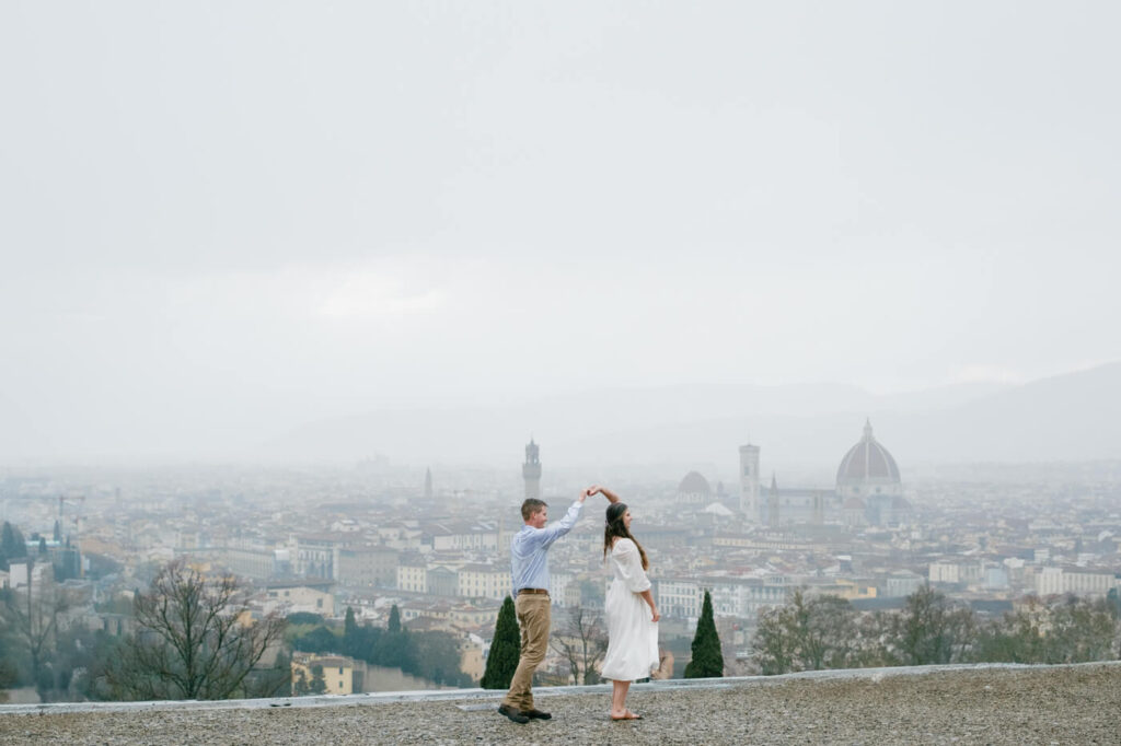 Dancing on a hilltop with Florence in the background – A couple twirls on a scenic overlook, with Florence’s Duomo and rolling hills creating a breathtaking backdrop.