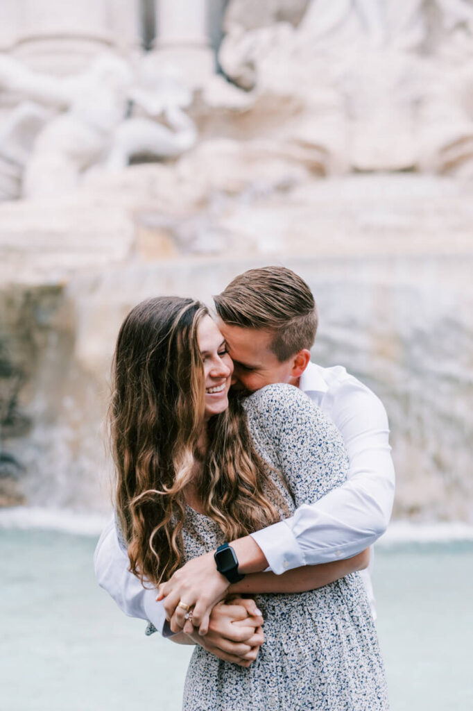 Romantic embrace at the Trevi Fountain – The couple shares a joyful, intimate moment in front of the Trevi Fountain’s cascading waters, surrounded by intricate marble sculptures.