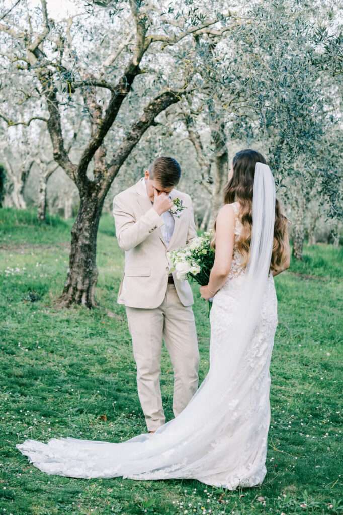 Groom’s emotional reaction as he sees his bride during the first look in the olive tree grove.