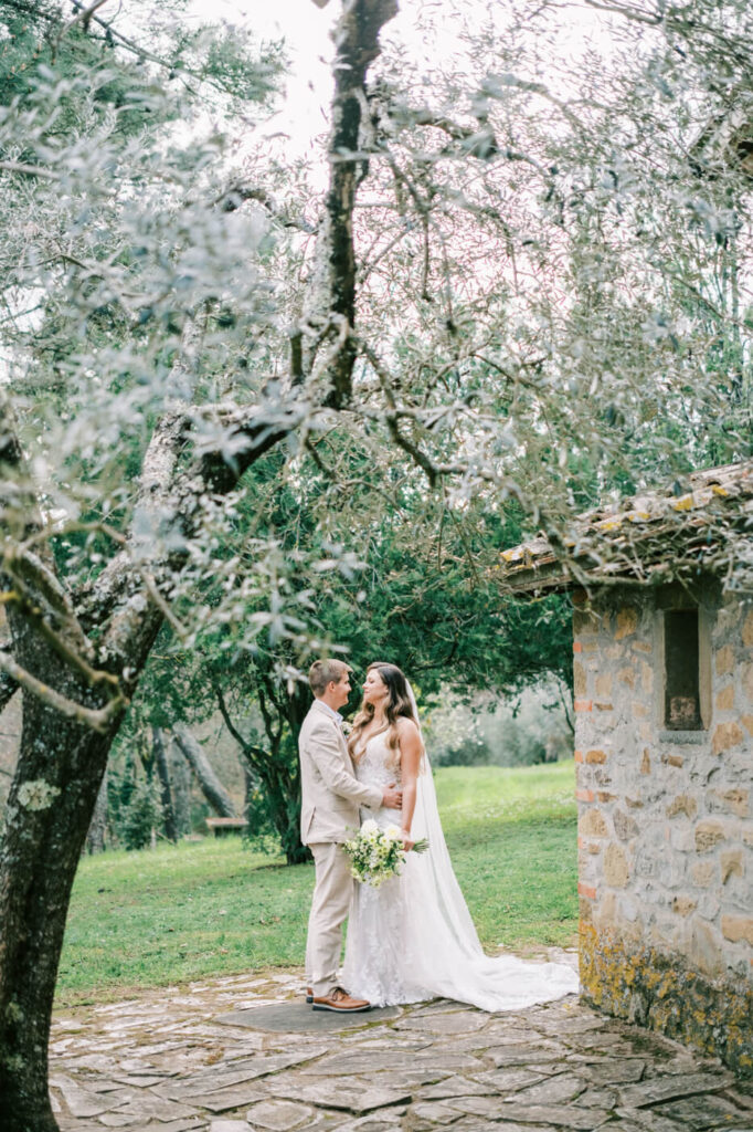 The couple steals a quiet moment before their ceremony, wrapped in each other’s arms next to Tuscan villa.