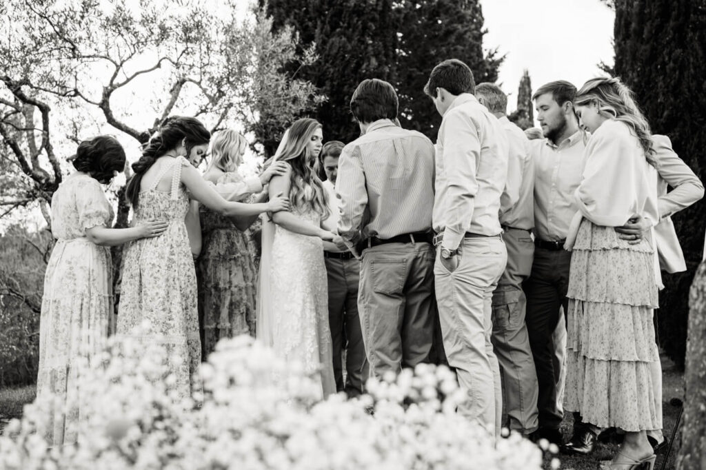 A heartfelt moment—family and friends surround the bride in a touching prayer before the ceremony begins.